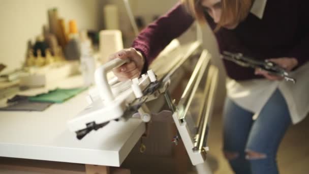 Junge Frau stellt Strickmaschine für die Arbeit in der heimischen Werkstatt ein — Stockvideo