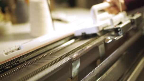 Las manos femeninas haciendo textura de punto en la máquina de tejer — Vídeo de stock