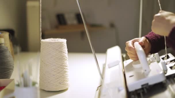 Tissu de tissage des mains féminines sur machine à tricoter en atelier — Video