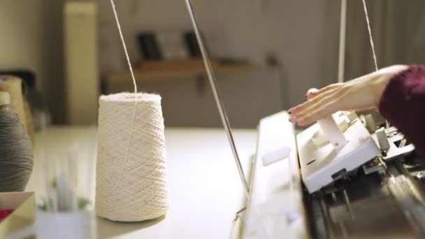Manos femeninas usando máquina de tejer para tejer tela en el taller — Vídeos de Stock