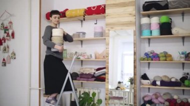 Stillage Tekstil atölyesinde üzerinde yaratıcı kadın raf iplik biriktirme