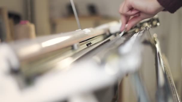 Las manos femeninas preparando la máquina de tejer para el trabajo en el taller — Vídeos de Stock