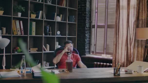 비즈니스 사람 신중한 얼굴로 사무실의 자에 앉아 위스키를 마시는 — 비디오