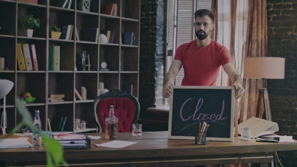 Empresario sacando letrero cerrado y poniéndolo en el escritorio — Vídeos de Stock