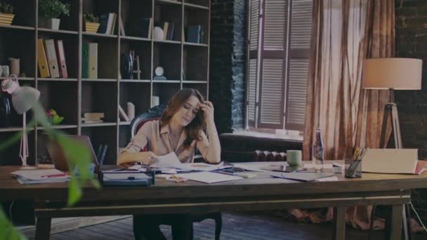 Mujer de negocios concentrada sentada a la mesa y leyendo cuidadosamente el contrato — Vídeos de Stock