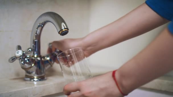 Kvinna hand låsvred på kran och hälla vatten i glas — Stockvideo