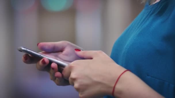 Female hands with red thread touching screen on mobile phone side view — Stock Video