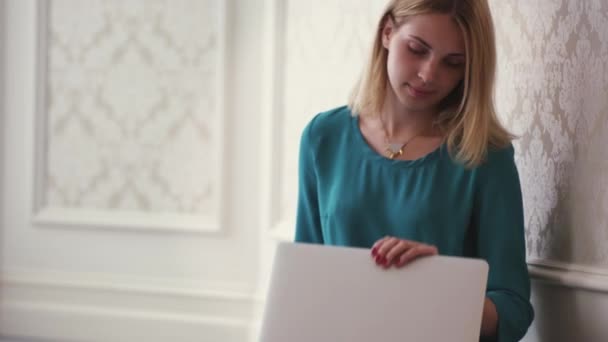 Молодая женщина открывает ноутбук для просмотра Интернета в интерьере комнаты — стоковое видео