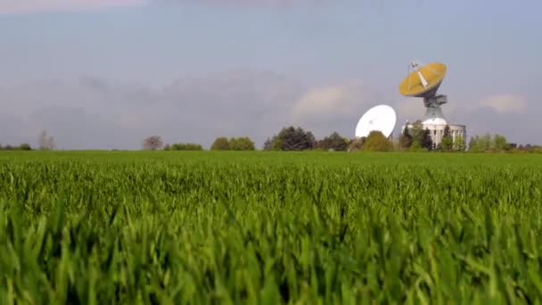 Schotelantenne op platteland. Ruimtetelescoop bijhouden op brede groene veld — Stockvideo