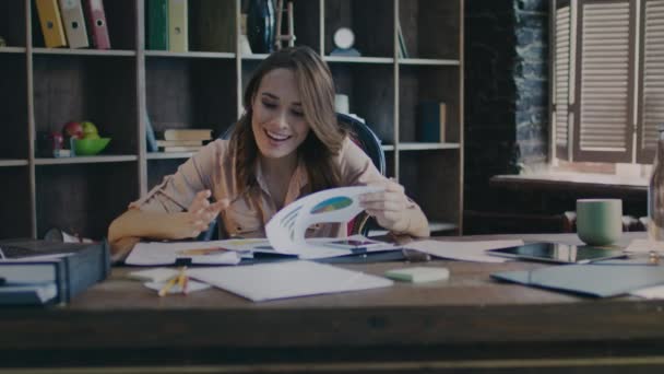 Gelukkig zakenvrouw glimlachend en analyseren van gegevens in office. Goed zakelijk nieuws — Stockvideo