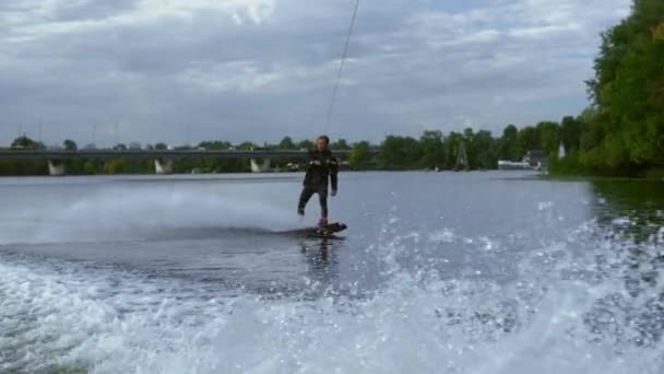 Homme chevauchant wakeboard sur vague de bateau à moteur dans la rivière d'été. Vie active — Video