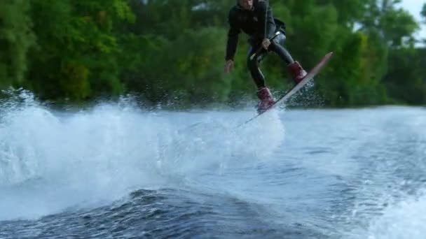 Réveillez cavalier planche sautant haut au-dessus de l'eau. Réveillez cavalier surf sur l'eau — Video