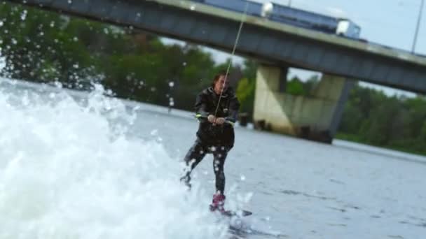 Jongeman wakeboard rijden op zomer rivier. Waterskier bewegen snel in spatten — Stockvideo