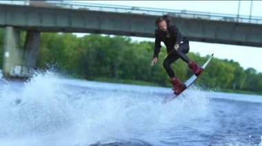 Atlet wakeboarder suyun üstünde yüksek atlama. Su üzerinde aşırı dublör