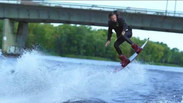 Atleta wakeboarder saltando muy por encima del agua. Truco extremo sobre el agua — Vídeos de Stock