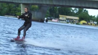 Siyah mayo wakeboarding içinde enerji sporcu. Göl sörf Wakeboarder