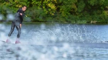 Su sıçramalarına içinde yakışıklı adam wakesurfing. Genç adam sürme wakeboard