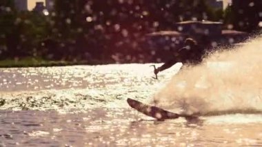Adam sürme wakeboard gün batımında. Aşırı bir yaşam tarzı. Binici zevk aşırı tatil