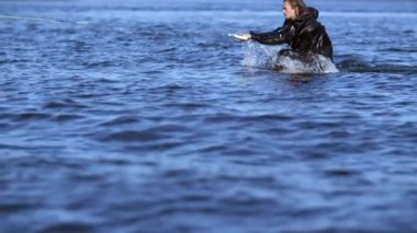 Adam ağır çekimde wakeboarding başlatın. Sporcu üzerinde wakeboard sürme
