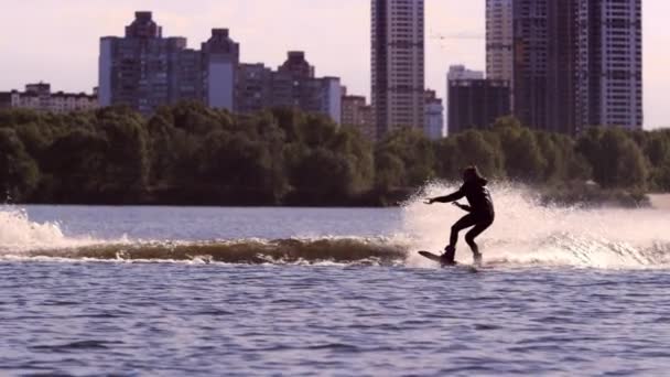 Guy haasten langs meer op Waterschap in slow motion. Extreme sport wakeboarden — Stockvideo