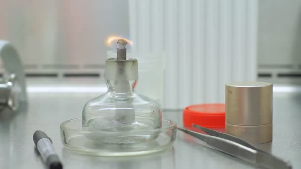 Candle stick met vuur op laboratorium tafel. Brand vlam in lab bekerglas — Stockvideo