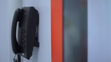 Arama telefon turuncu çizgili beyaz duvar. İletişim teknolojisi