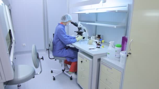 Técnico de laboratório usando microscópio de laboratório. Pesquisador fazendo experiência — Vídeo de Stock