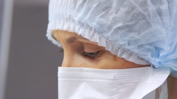 Laboratorium werknemer gezicht in beschermend masker op zoek weg. Dokter gezicht in masker — Stockvideo