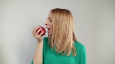 Kırmızı elma yiyen sarışın kadın portresi. Sarışın kız organik meyve ısırma