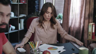 Ofis toplantı arkadaşlarıyla sırasında düzensiz masada oturan iş kadını