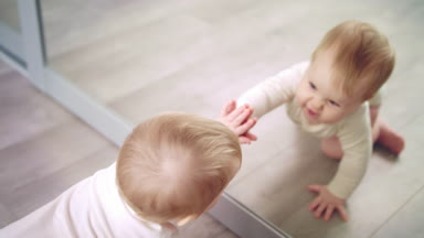 Küçük bebek aynayla oynuyor. Tatlı çocuk aynası. Sevimli çocuk oyunu evi.