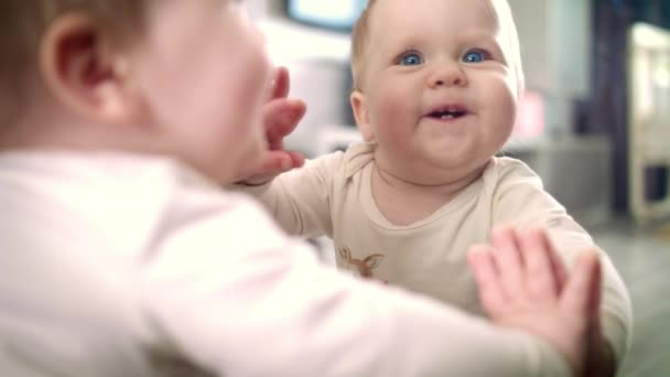 Novorozené dítě úsměv a hrát si se zrcadlovým odrazem. Kojenec si hraje doma