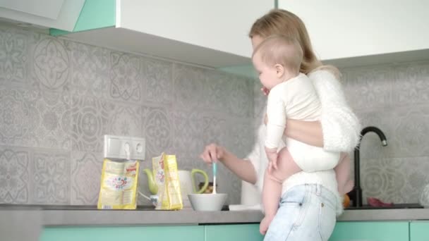 Moeder bereidt eten voor kleine baby in de keuken. Moederzorg kind — Stockvideo