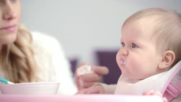 Mom feed baby. Dissatisfied child eat pureed food. First feeding infant — Stock Video