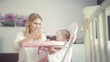 Güzel anne, bebeği lapayla beslemeyi dene. Bebek kemiren teether 'lar