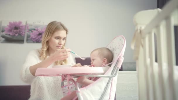 Gyönyörű anya, próbáld meg zabkásával etetni a babát. Csecsemőrágó fogak — Stock videók