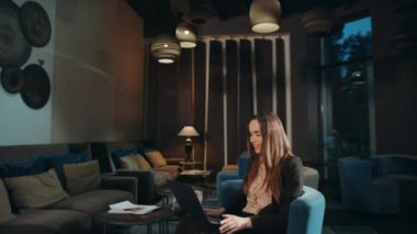 İş kadını otel lobisindeki dizüstü bilgisayardan görüntülü konuşmayı arıyor.