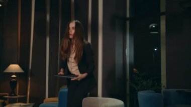 Gece otel odasında dizüstü bilgisayar kullanan düşünceli bir iş kadını.