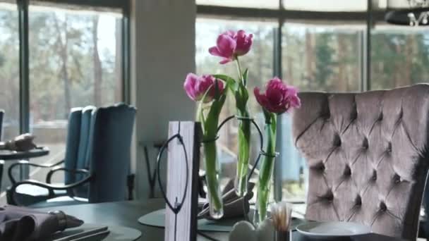 Plate with napkin and cutlery for dinner in restaurant. Flowers on dining table — Stock Video