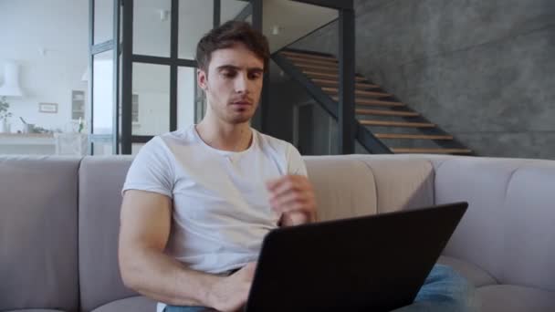 Gros plan jeune homme ordinateur portable de travail à la maison au ralenti . — Video