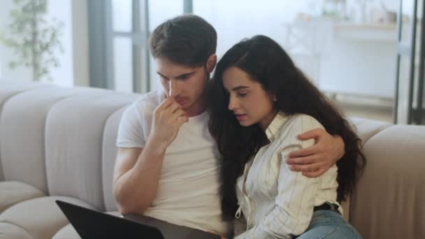 Jovem casal assistindo computador portátil em casa em câmera lenta — Vídeo de Stock