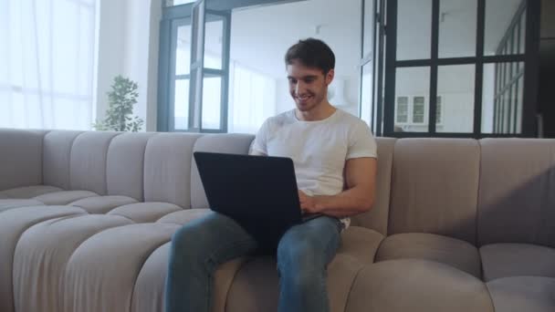 Feliz hombre de negocios haciendo sí gesto cerca de la computadora portátil en el lugar de trabajo remoto . — Vídeos de Stock