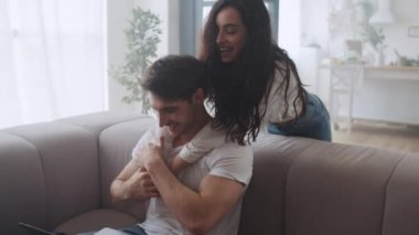 Evdeki kanepede ağır çekimde koşup zıplayan neşeli kadın.