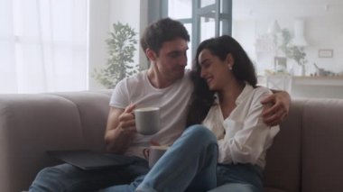 Evde kahve içen mutlu çift. Kanepede konuşan seksi erkek ve kadın..