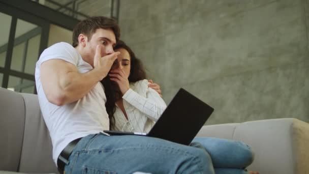 Portrait de couple effrayé regardant ordinateur portable à la maison au ralenti . — Video