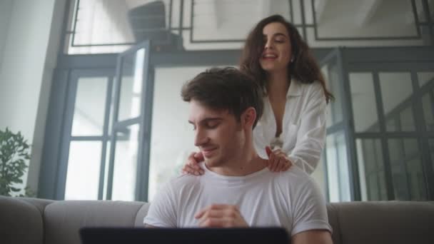 Επιχειρηματίας που εργάζεται σε φορητό υπολογιστή στο σπίτι. Ευτυχισμένο ζευγάρι αγκαλιάζει στο σπίτι — Αρχείο Βίντεο