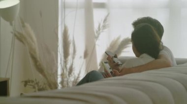 Birlikte cep telefonu izleyen mutlu çiftin arka plan görüntüsü.