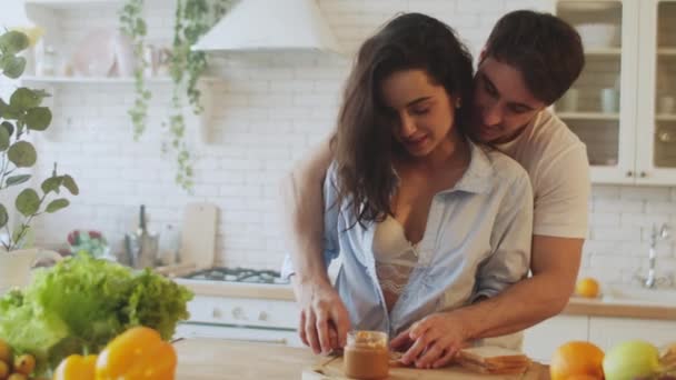 Closeup pessoas bonitas se divertindo com manteiga de amendoim em casa . — Vídeo de Stock