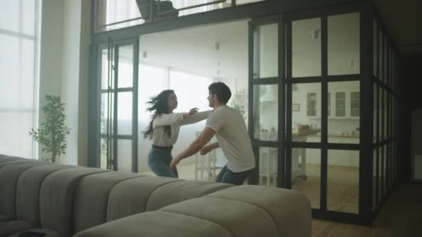 Un couple heureux qui tourne dans une nouvelle maison. Couple joyeux célébrant la relocalisation — Video