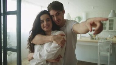 Mutlu çift yeni evinde sarılıyor. Yakın plan, aile içi planlama.
